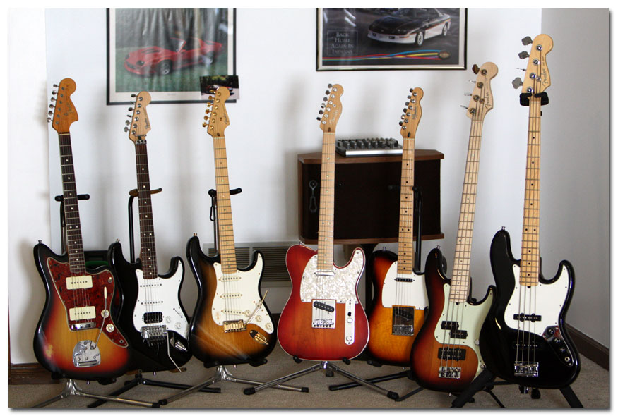 Left to right: Fender Jazzmaster, Custom Fender Fat Strat, Fender 50th Anniversary American Deluxe Strat, Fender American Deluxe Tele, Fender Telecaster, Fender American Deluxe Precision Bass, Fender American Standard Jazz Bass