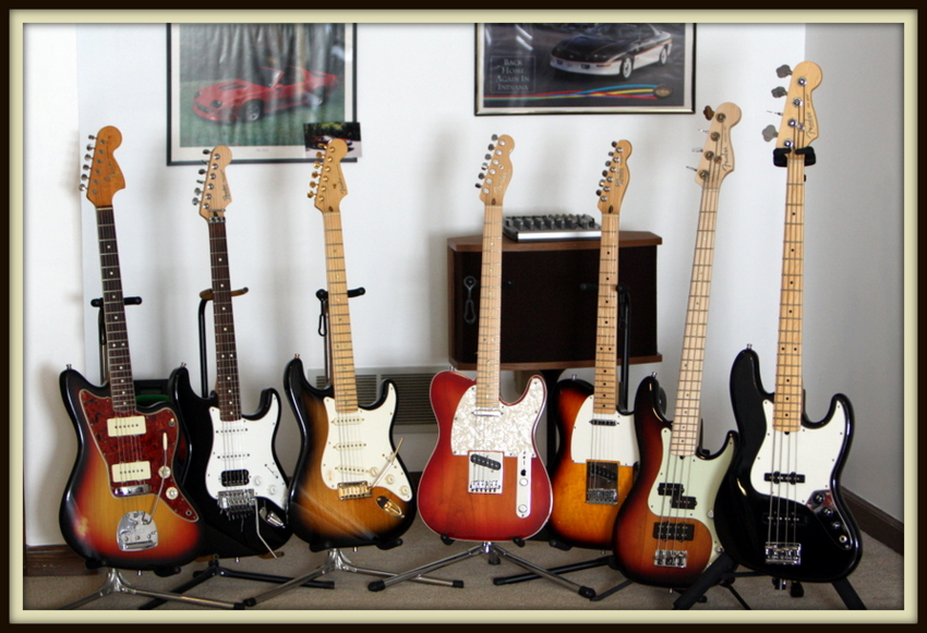 Left to right: Fender Jazzmaster, Custom Fender Fat Strat, Fender 50th Anniversary American Deluxe Strat, Fender American Deluxe Tele, Fender Telecaster, Fender American Deluxe Precision Bass, Fender American Standard Jazz Bass